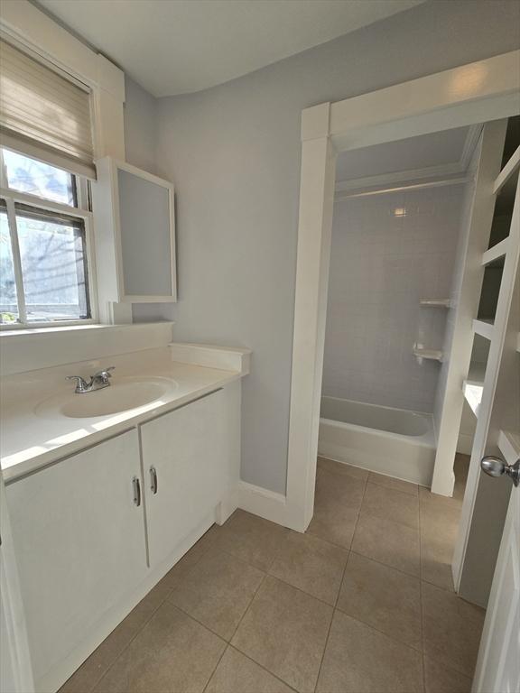 full bathroom with tile patterned floors, vanity, baseboards, and shower / washtub combination