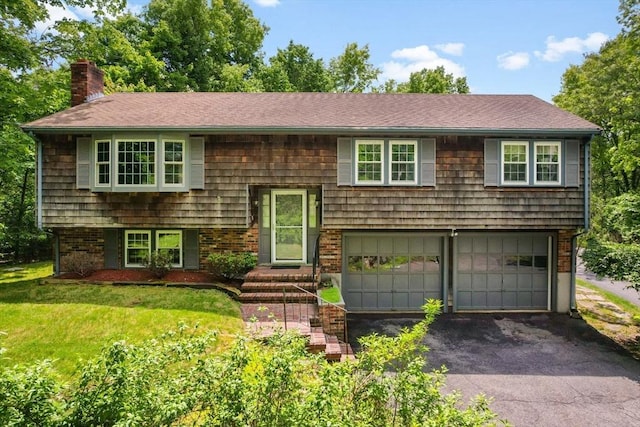 27 Woodland St, Natick, MA 01760 - raised ranch with a chimney, an attached garage, asphalt driveway, a front lawn, and a shingled roof