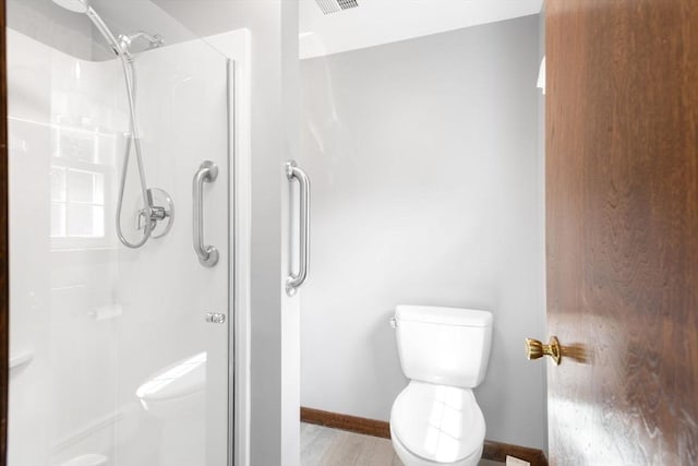 27 Woodland St, Natick, MA 01760 - bathroom featuring toilet, a stall shower, baseboards, and wood finished floors