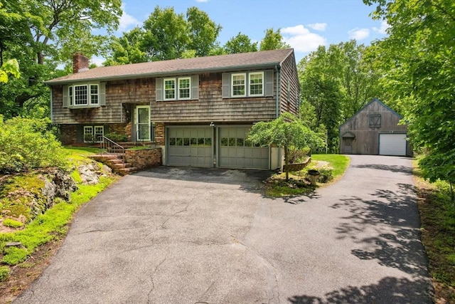 27 Woodland St, Natick, MA 01760 - raised ranch featuring a chimney, driveway, an attached garage, and an outdoor structure