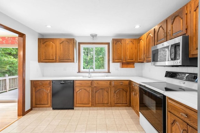 27 Woodland St, Natick, MA 01760 - kitchen with stainless steel microwave, dishwasher, electric range oven, brown cabinets, and recessed lighting