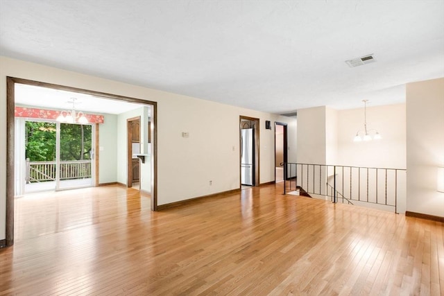 27 Woodland St, Natick, MA 01760 - unfurnished room with a chandelier, light wood-style floors, and baseboards