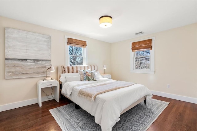 bedroom featuring wood finished floors, visible vents, and baseboards