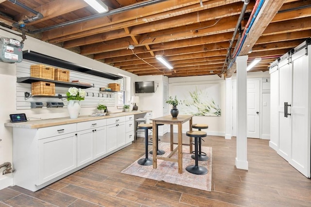 interior space featuring dark wood-type flooring, baseboards, light countertops, white cabinetry, and open shelves