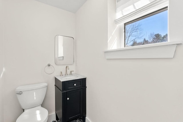 bathroom with vanity, toilet, and baseboards