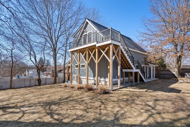 back of property featuring stairway, fence, a deck, board and batten siding, and metal roof