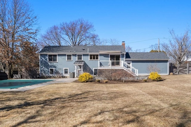 view of front facade featuring a chimney, a front lawn, a covered pool, fence, and stairs