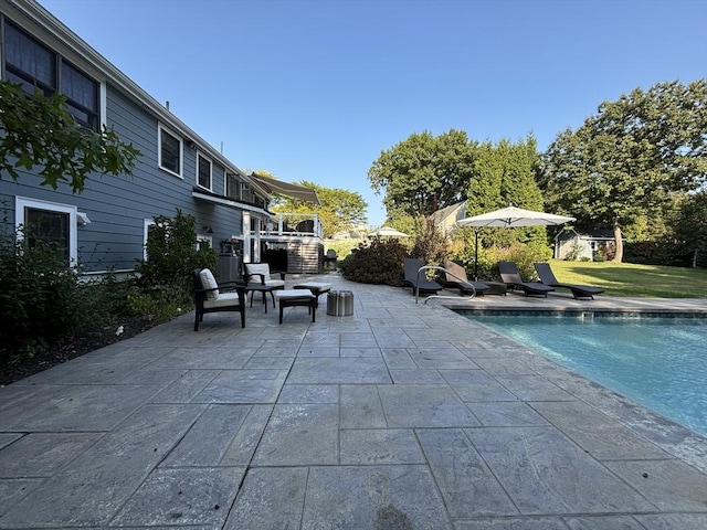 outdoor pool with a lawn and a patio area