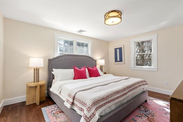 bedroom featuring visible vents, baseboards, and wood finished floors