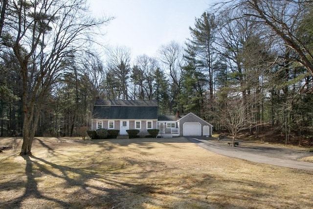 colonial inspired home featuring a gambrel roof, an attached garage, driveway, and a front lawn