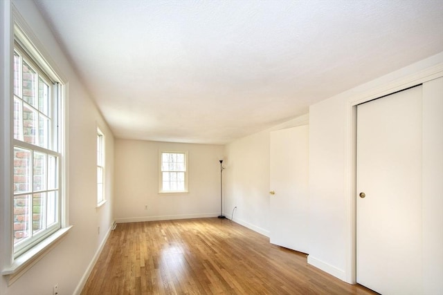 unfurnished room with light wood-style flooring and baseboards