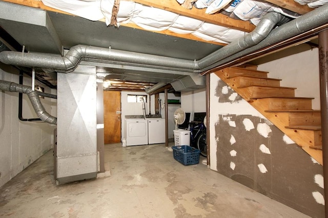 unfinished basement featuring washing machine and clothes dryer, stairway, and heating unit