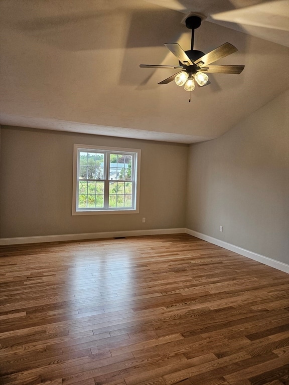 spare room with ceiling fan, wood-type flooring, and lofted ceiling