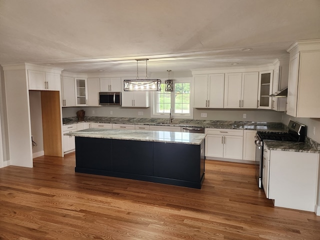 kitchen featuring a center island, white cabinets, stainless steel appliances, and hardwood / wood-style flooring