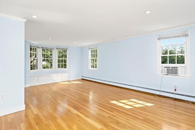 empty room featuring crown molding, light wood-type flooring, cooling unit, and a baseboard heating unit