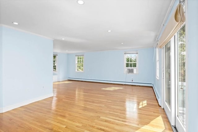 empty room featuring baseboard heating, ornamental molding, and light hardwood / wood-style flooring