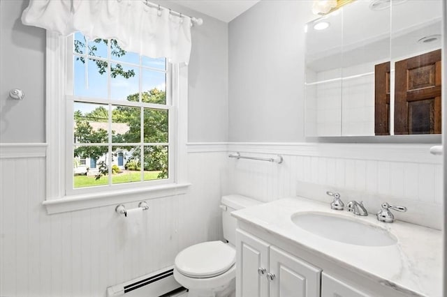 bathroom with vanity, a baseboard heating unit, a shower, and toilet