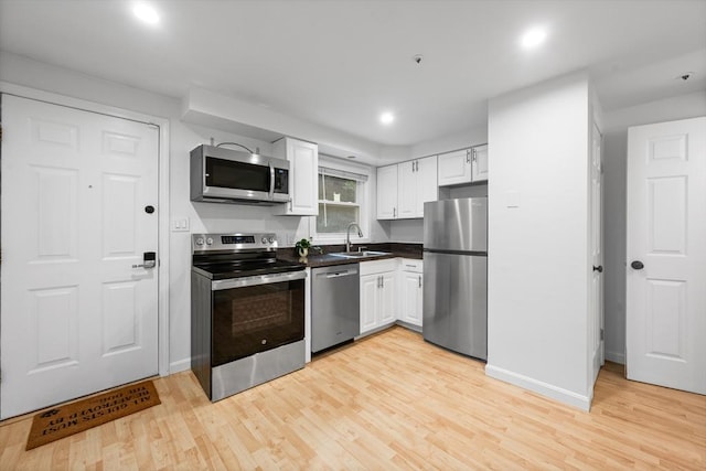 19 Dalrymple St Unit D, Boston, MA 02130 - kitchen featuring stainless steel appliances, white cabinetry, light wood-type flooring, dark countertops, and recessed lighting