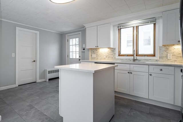 kitchen featuring sink, radiator heating unit, white cabinets, and a kitchen island