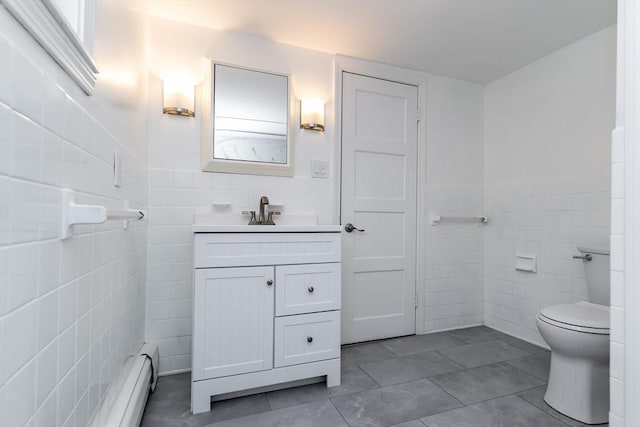 bathroom with tile walls, vanity, tile patterned floors, and toilet