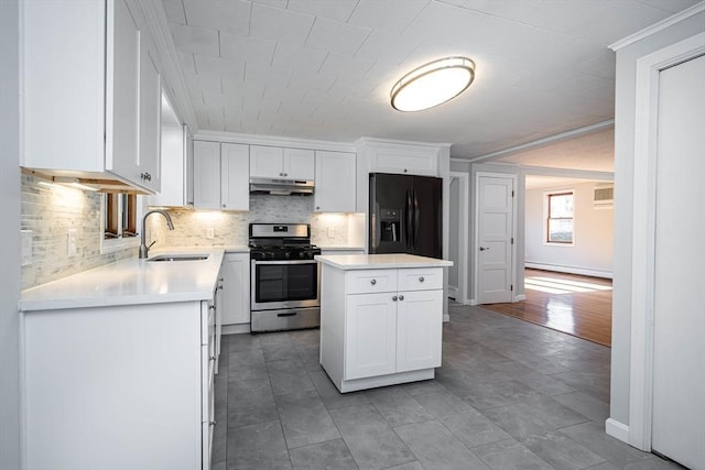 kitchen featuring sink, a center island, stainless steel gas range oven, white cabinets, and black fridge