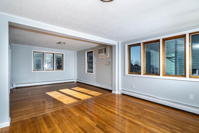 unfurnished room featuring wood-type flooring, a baseboard heating unit, a wall mounted AC, and a textured ceiling