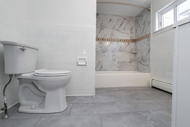 bathroom with tile patterned floors, toilet, tiled shower / bath, tile walls, and a baseboard heating unit