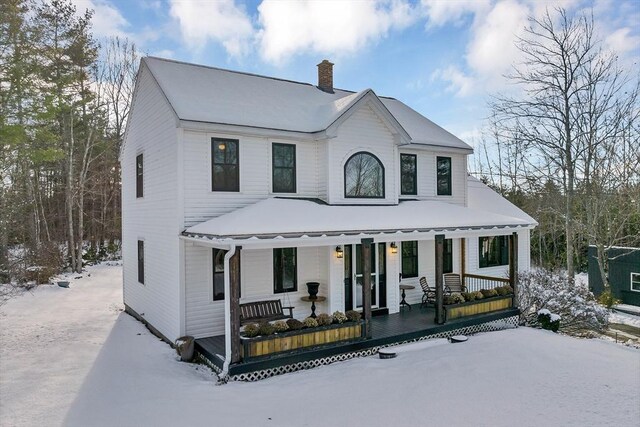 view of front of property featuring covered porch and a chimney