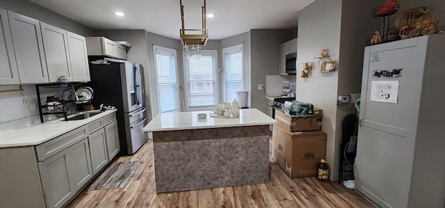 8 Suffield St, Worcester, MA 01610 - kitchen featuring stainless steel appliances, a center island, light wood-style floors, a sink, and recessed lighting