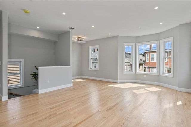 unfurnished living room with plenty of natural light and light hardwood / wood-style floors