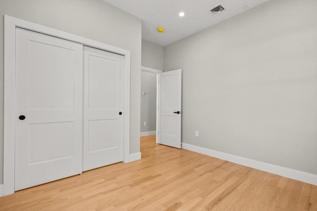 unfurnished bedroom with a closet and light wood-type flooring