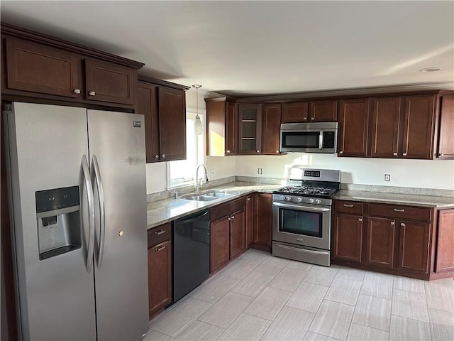 55 Swan St, East Providence, RI 02914 - kitchen with dark brown cabinetry, decorative light fixtures, a sink, and appliances with stainless steel finishes