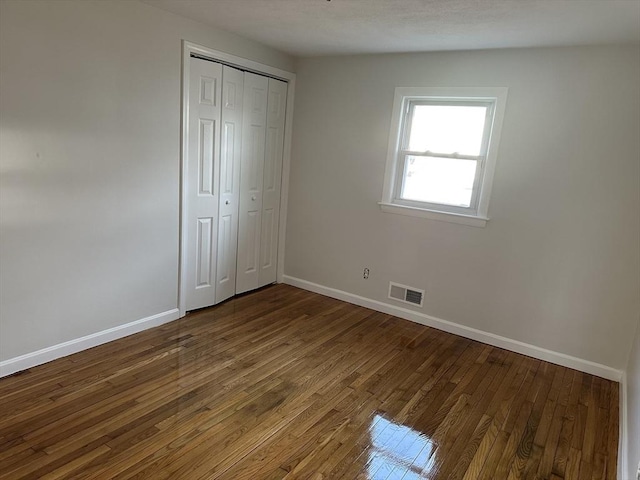 55 Swan St, East Providence, RI 02914 - unfurnished bedroom featuring a closet, wood finished floors, visible vents, and baseboards