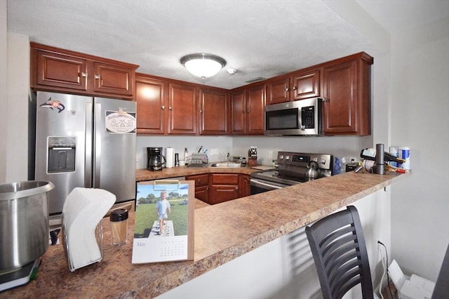272 N Farm Dr Unit 272, Bristol, RI 02809 - kitchen with stainless steel appliances, a sink, a breakfast bar area, a peninsula, and light countertops