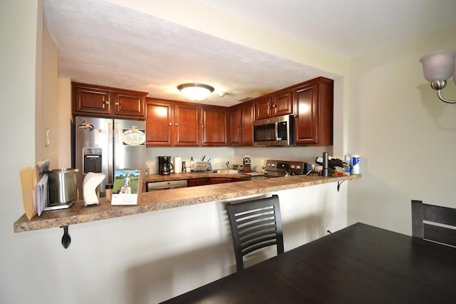 272 N Farm Dr Unit 272, Bristol, RI 02809 - kitchen featuring stainless steel appliances, a peninsula, a kitchen breakfast bar, and a sink