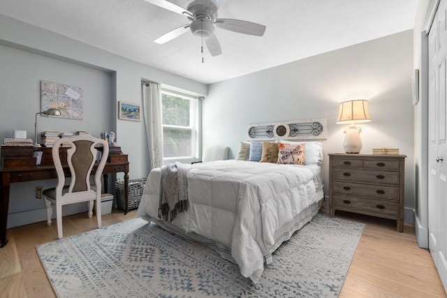 bedroom with light wood-style floors and a ceiling fan