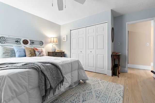 bedroom featuring a closet, light wood-type flooring, a ceiling fan, and baseboards