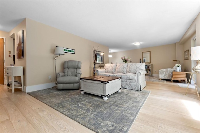 living area with light wood-type flooring and baseboards
