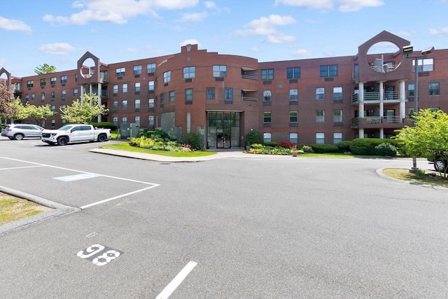 view of apartment building / complex featuring uncovered parking