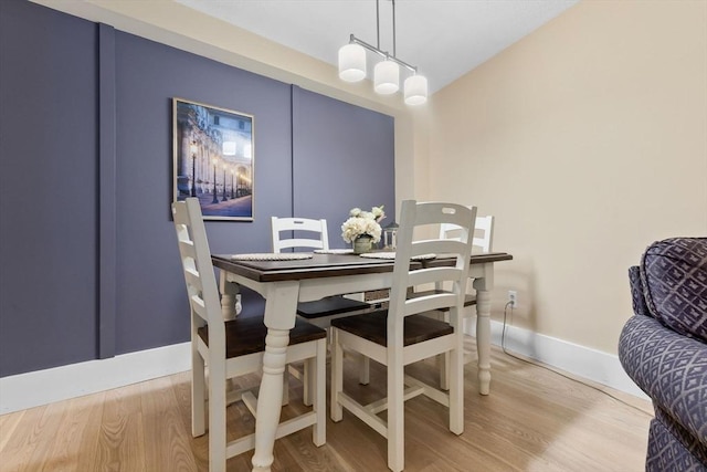 dining space featuring wood finished floors and baseboards