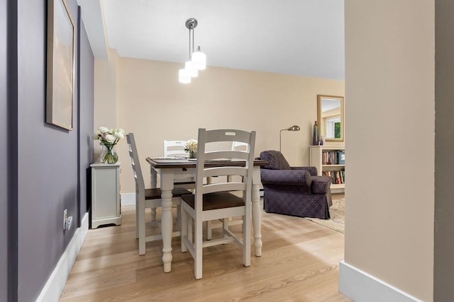 dining room featuring light wood finished floors and a chandelier