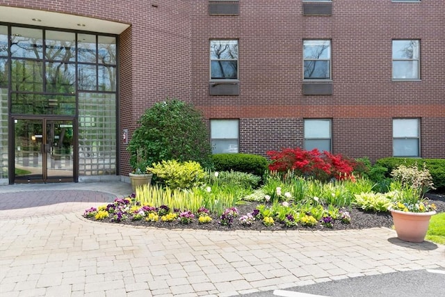property entrance featuring french doors and brick siding