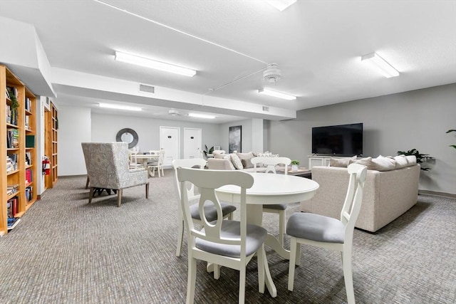 carpeted dining room with baseboards