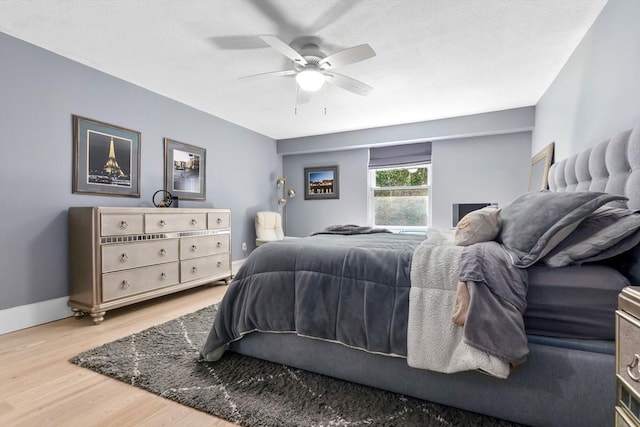 bedroom featuring wood finished floors, ceiling fan, and baseboards