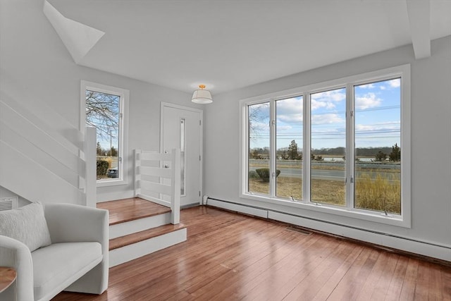 1705 Wampanoag Trl, Barrington, RI 02806 - foyer entrance featuring plenty of natural light, a baseboard radiator, stairs, and hardwood / wood-style flooring