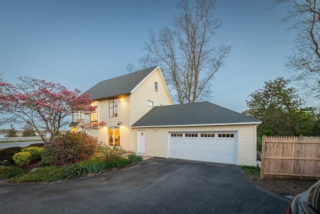 1705 Wampanoag Trl, Barrington, RI 02806 - view of side of property with asphalt driveway, an attached garage, and roof with shingles