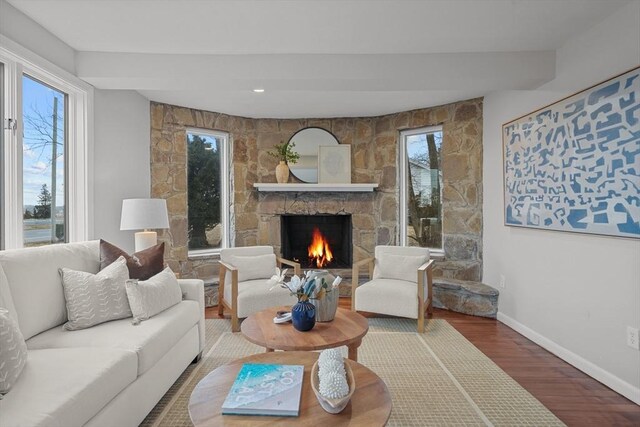 1705 Wampanoag Trl, Barrington, RI 02806 - living room with wood finished floors, a stone fireplace, baseboards, and plenty of natural light