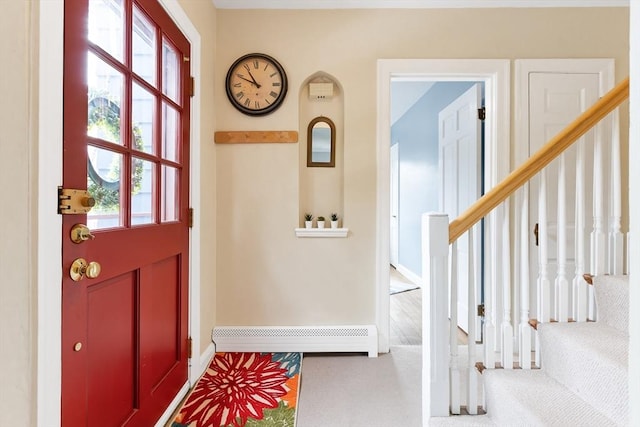 carpeted entryway featuring a baseboard radiator, stairway, and baseboards