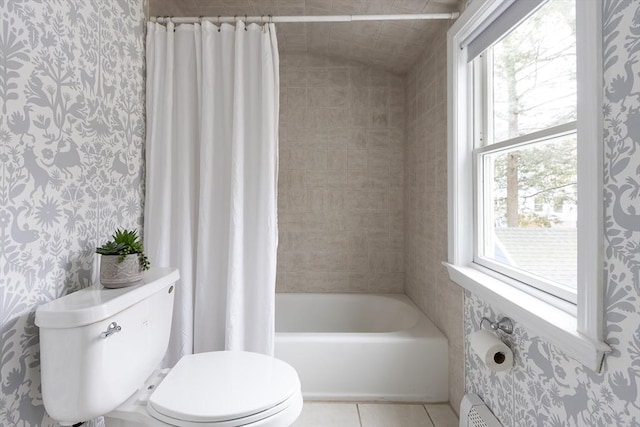 full bathroom featuring lofted ceiling, tile patterned flooring, toilet, wallpapered walls, and shower / bathtub combination with curtain