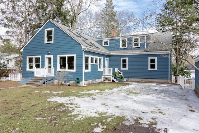 back of house with a shingled roof, a chimney, and fence